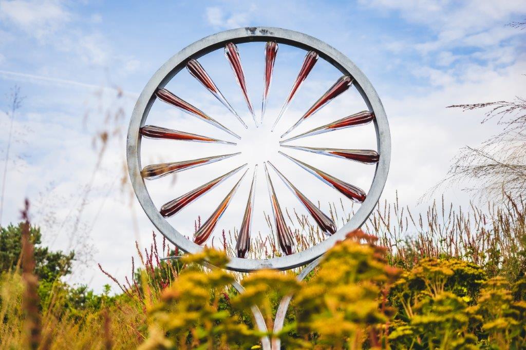 A sculpture in the shape of a wheel with each spoke pointing to the bright centre representing customer centricity.