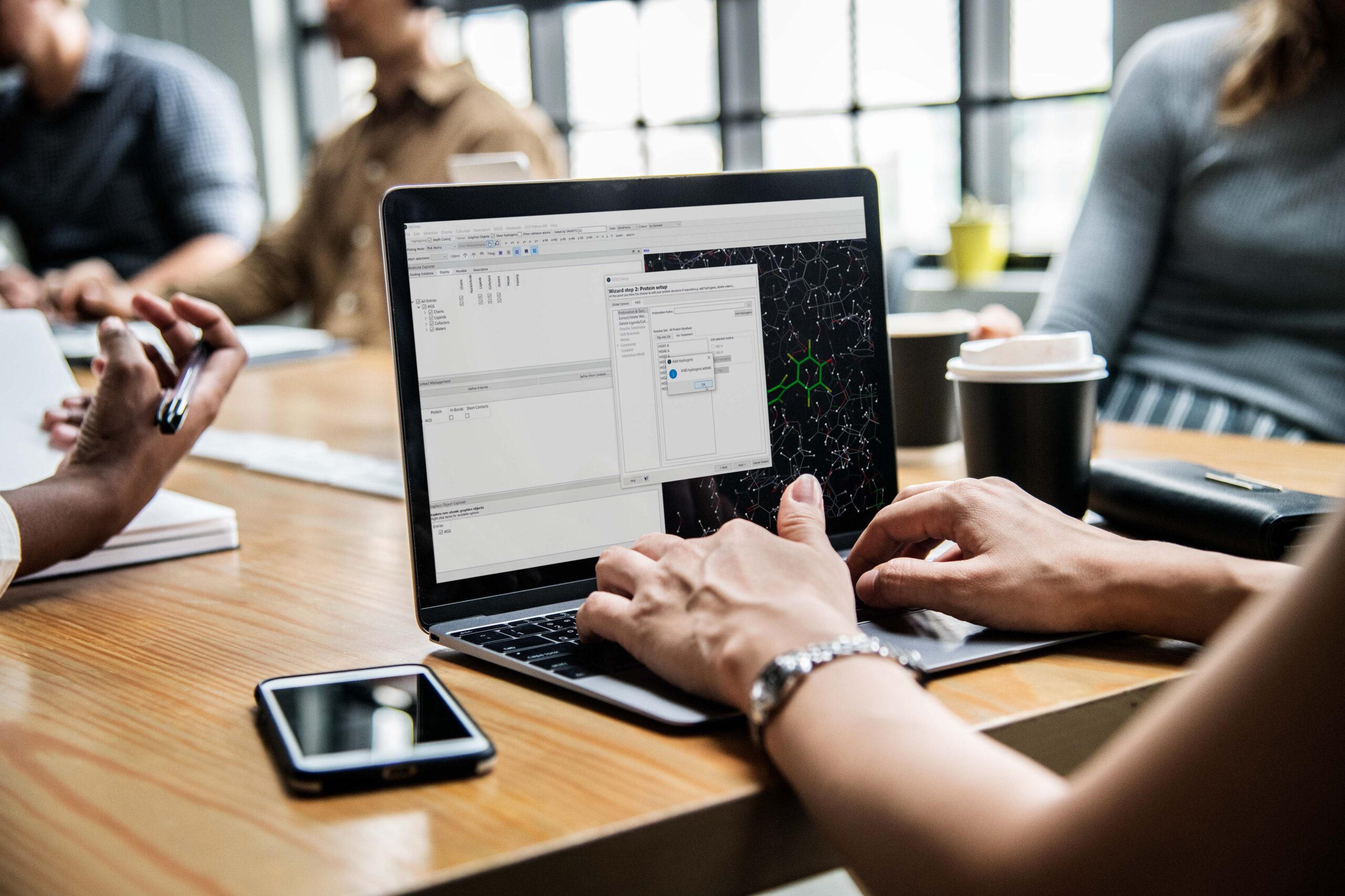 Someone using a laptop with the GOLD software shown on screen.