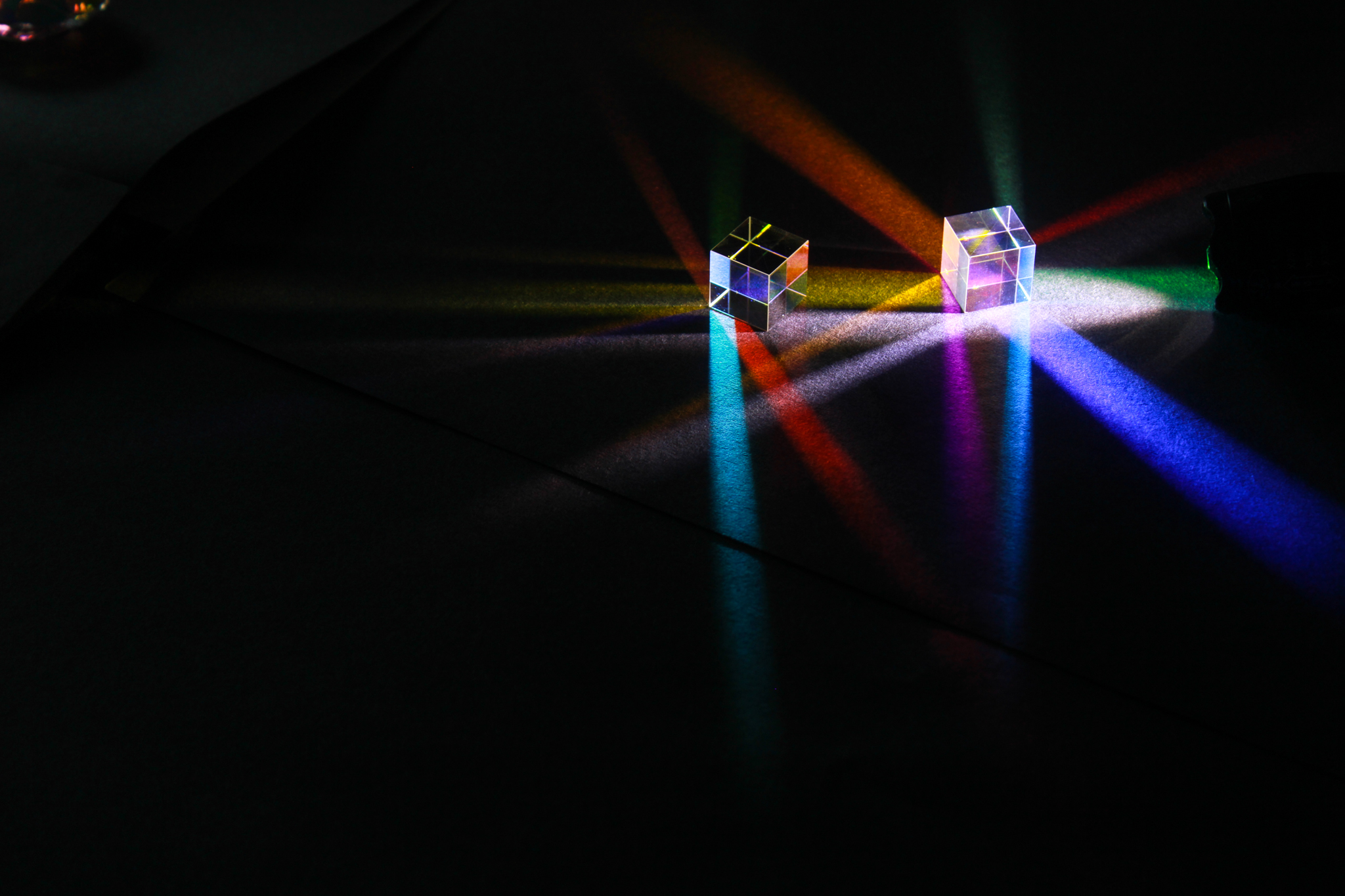 Photograph taken by students showcasing different light patterns through dichroic cubes and prisms