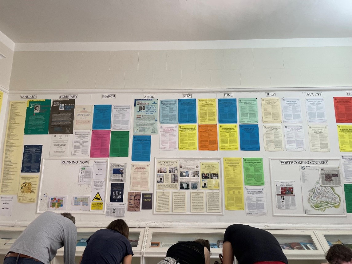 Picture of a wall with posters from all the schools held in Erice.
