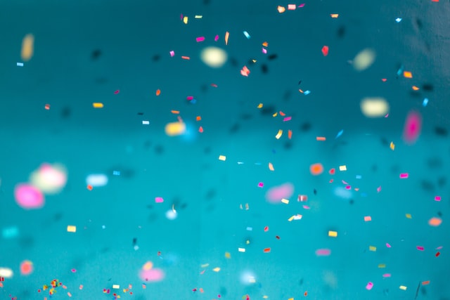 A colorful explosion of confetti in various shapes and sizes, creating a vibrant and festive atmosphere.